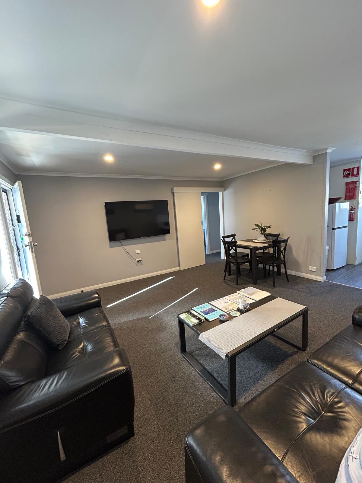Lounge seating with flat-screen TV in Apartment Three